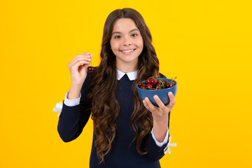 Sticker - Teenager child girl hold plate cherries isolated on yellow background. Summer berries, kids healthy cherry fruits. Cherry for kids.