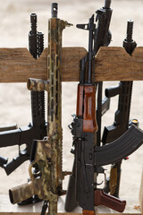 Modern American 5.56mm assault rifle and Kalashnikov 5.45mm on a weapon stand at outdoor shooting range