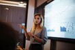 © InputUX - Candid young professional woman giving engaging corporate presentation, charts on screen, audience listening attentively, generative ai