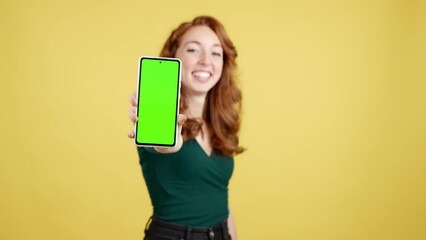 Green screen of the mobile held by a redheaded woman