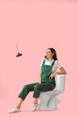 Sticker - Female plumber sitting on toilet bowl and flying plunger against pink background