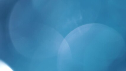 Wall Mural - Blue Large Bokeh Circular Motion Background. Moving 4K background. Huge defocused bokeh circles smooth movement with lights reflexes. Can be used as background, overlay or transition.