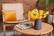 © Pixel-Shot - Vase with narcissus flowers and magazines on coffee table in living room