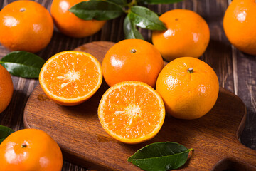 Fresh mandarin oranges or tangerines on wooden table.