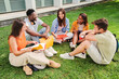 © Jose Calsina - Group of multiracial teenage students sitting on the lawn, talking and smiling together at university campus. College young friends sleadning and tudying on the grass. Education concept. High quality