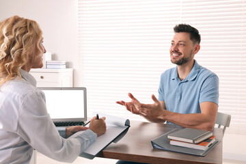 Wall Mural - Doctor consulting patient at table in clinic