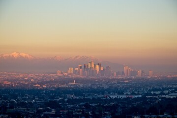 Wall Mural - Snow tops the San Gabriel Mountains that tower above Los Angeles as evening falls on the city.