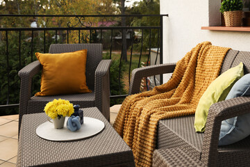 Canvas Print - Colorful pillows, soft blanket and yellow chrysanthemum flowers on rattan garden furniture outdoors