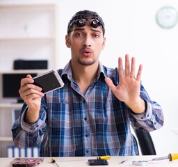 Wall Mural - Young handsome technician repairing mobile phone