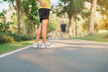 Wall Mural - man jogging and walking on the road at morning, adult male in sport shoes running in the park outside. Exercise, wellness, healthy lifestyle and wellbeing concepts