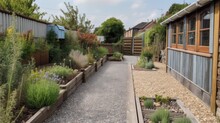 A View Looking Down A Back Garden Of A Home With Paving Slaps And Gravel, Pea Shingle, Wooden Railway Sleeper Flower Bed, Vegetable Patch, Potted Plants, Timber Fence, Grey Summerhouse, Generative Ai