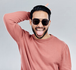 Sticker - Portrait, tongue out and Asian man with sunglasses, funny and silly against a grey studio background. Face, Japanese male and guy with funky eyewear, shades and comic with humor and goofy expression