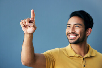 Poster - Finger, pointing and happy man in studio with hand gesture, sign or showing mockup on blue background. Smile, point and asian male with idea on space for advertising, product placement and isolated