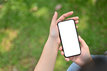 Top view of a woman using her phone in the park. phone white screen mockup
