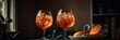Aperol Spritz, two glasses with ice cubes and orange slices, dark background, wide