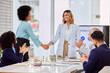 © Lune/peopleimages.com - Applause, business people and handshake in office for welcome, thank you or hiring in meeting. Team, collaboration and women shaking hands for integration, synergy or deal, partnership and promotion