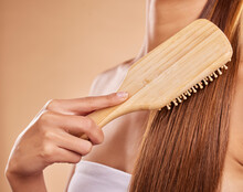 Hairbrush, Hair Care And Woman Brushing Her Hair In A Studio For Wellness, Health And Self Care. Cosmetic, Beauty And Closeup Of A Female Model Doing A Hairstyle Or Combing Knots By Brown Background.