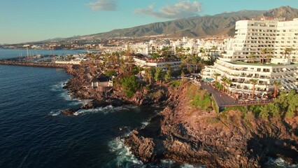 Wall Mural - Flight over Costa Adeje resort town at sunset in Tenerife, Canary islands, Spain
