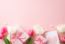 Mother's Day Celebration Concept. Top View Photo Of Gift Boxes With Ribbon Bows Pink And White Tulips Envelope With Letter And Small Hearts On Isolated Pastel Pink Background With Copyspace