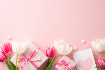Wall Mural - Mother's Day celebration concept. Top view photo of gift boxes with ribbon bows pink and white tulips envelope with letter and small hearts on isolated pastel pink background with copyspace