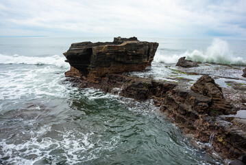 Rocky sea coast hit by waves on Bali island