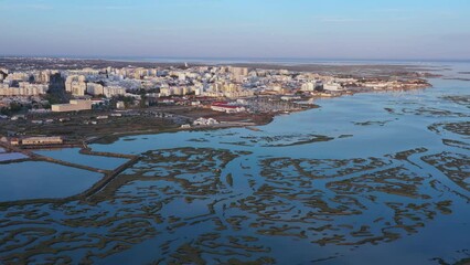 Canvas Print - Beautiful aerial views of the Ria Formosa of the Portuguese southern town of Faro, with salt lakes and houses. Drone movement right,. Sunset