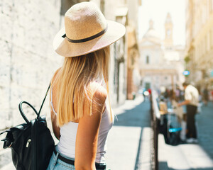 Wall Mural - Young attractive smiling girl tourist exploring new city at summer