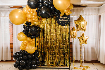 arch decorated with black, brown, golden balloons and stars. photo-wall decoration space, place with