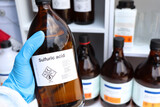 Fototapeta Maki - sulfuric acid in glass, Hazardous chemicals and symbols on containers