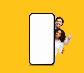 Poster - Nice Offer. Happy Multiethnic Couple Peeking Out Behind Big Blank Smartphone