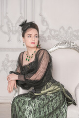 Beautiful young smiling woman wearing green medieval vintage Victorian Style dress