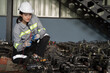Female electrician engineer inspecting quality parts of electric motor in spare parts warehouse