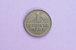 One german Mark coin marked 1 Deutsche Mark from 1968 on purple background.