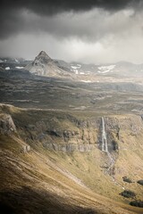 Canvas Print - Vertical aerial shot of Bjarnafoss waterfall falling down the cliff in Iceland on a cloudy day