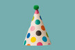 © Nikolay - Bright and colorful birthday cap isolated on a green background.
