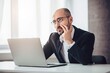© oleksandr.info - Frustrated businessman sitting at the desk with laptop and thinking about future
