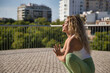 © Manuel - Middle-aged blonde woman, wearing green leggings and white top, doing meditation and yoga exercises outdoors. Concept yoga, meditation, concentration, sport, mindfulness.