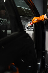 Wall Mural - Cleaning with air and brush of air conditioning system in the car. Worker in detailing auto service clean elements of interior of car.