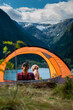 Traveling Norway, Young woman sits in the tent with her dog enjoying  Beautiful view of Buerdalen Valley and Sandvevatnet Lake near city of Odda Norway.