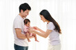 © geargodz - cheerful father and mother holding and playing with newborn baby on window background. happy family concept