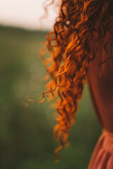 A girl with red curly hair. Nice long hair