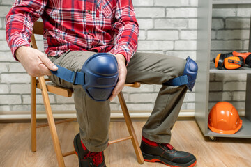  worker wearing safety equipment. a man wearing protective knee pads on the legs. work safety protection equipment