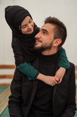 Wall Mural - A happy Muslim family child daughter hugging lovely father from behind.