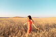 © Irina - Young woman in the wheat field. Connecting with nature concept. Moments of joy. Arms out to the side. Copy space