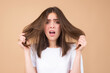 Sad girl with damaged hair. Haircare problem. Woman with hair loss problem. Portrait of young woman with a damaged bad hair. Girl with a hairbrush loosing hairs. Hair loss problem. Alopecia.