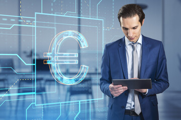 Wall Mural - Attractive young european businessman with tablet and glowing linear euro hologram standing on blurry office interior background. Investment, trade and finance concept. Double exposure.