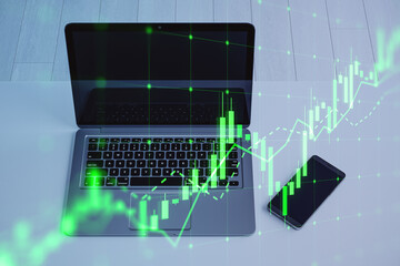 Aufkleber - Close up of laptop and cellphone with growing green candlestick chart on desktop background. Forex, trade and finance concept. Double exposure.