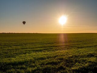 Wall Mural - Silhouette of hot air balloon flying above meadows of countryside near Ootmarsum, Overijssel, Netherlands