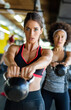 © NDABCREATIVITY - Group of fit people lifting dumbbells during an exercise class at the gym