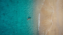 Aerial View Of Beautiful Happy Woman In Swimsuit Laying In The Shallow Sea Water, Enjoying Sandy Beach And Soft Turquoise Ocean Wave. Tropical Sea In Summer Season On Egremni Beach On Lefkada Island.